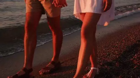 AI Video from prompt: A man in shorts and sandals and a woman in a whi