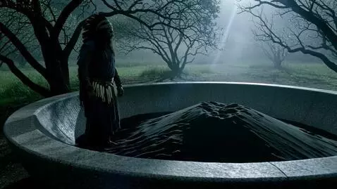 AI Video from prompt: a huge stone bowl filled with black sand. A lone