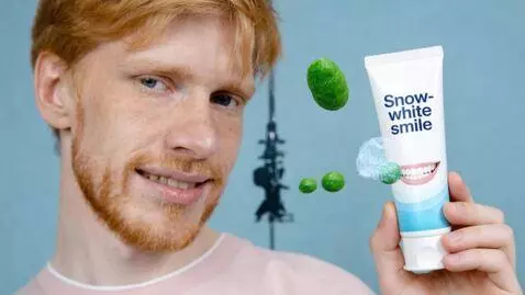 AI Video from prompt: A man holds a tube of toothpaste, smiling softly