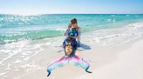 AI Video from prompt: A mermaid sits on the shore of a clear, transpar