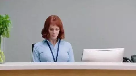 AI Video from prompt: a woman receptionist. suddenly her chest grows t