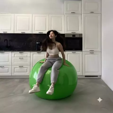 AI Video from prompt: A girl sits on a green fitball and a girl starts