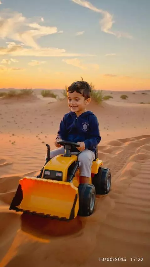 AI Video from prompt: little boy wearing navy blue jacket, driving yel