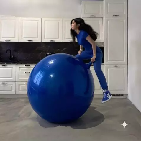 AI Video from prompt: The girl quickly sits down on the blue fitball a
