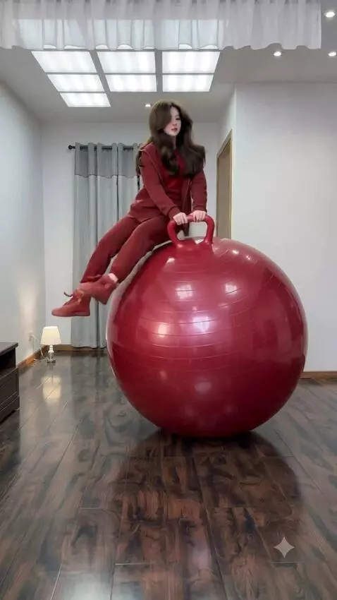 AI Video from prompt: The girl quickly sits down on the fitball, and t