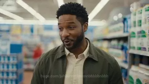 Parents smiling and talking to their son in a supermarket aisle, celebrating his good behavior.