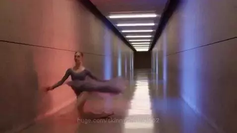 Ballerina in a grey leotard and purple skirt dances in a corridor with warm-to-cool lighting, showcasing temporal effects.
