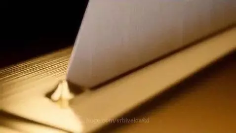 Macro shot of pure gold being sliced slowly with a clean, smooth cut, showcasing texture and shine.