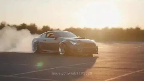 Dark sports car with wide body kit performing a drift, creating significant tire smoke, with trees and a golden sunset in the background.