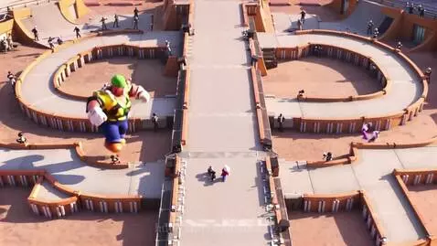 Giant muscular Luigi and Mario characters racing on a dusty stadium track with spectators.