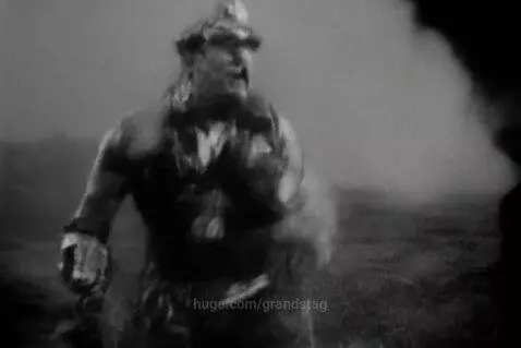 Black and white grainy footage of a man transforming into a monstrous figure with abstract dark imagery and distorted text overlays.