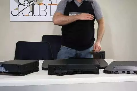 IT Director wearing a vest with 'IT DIRECTOR' text, standing in a greenhouse and destroying electronic devices on a table.