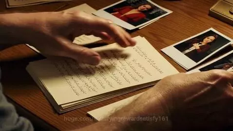 Male hands sorting through old letters and Polaroid photographs on a wooden table.