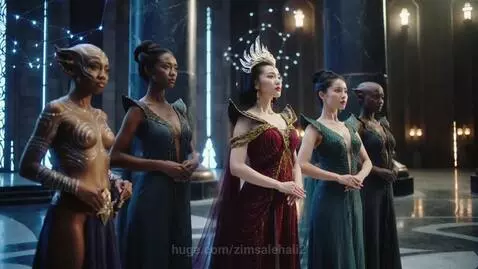 Five women in a dimly lit hall, some as alien warriors with pointed ears and body paint, others in elegant gowns, one crowned as a princess.