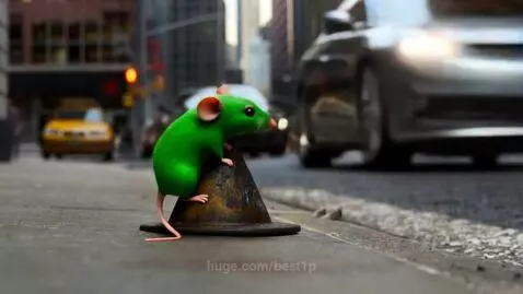 Animated green mouse with pink ears and tail jumps onto a small traffic cone on a city sidewalk.