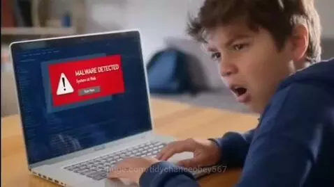 Young boy in blue hoodie looking surprised at a laptop screen showing a 'MALWARE DETECTED' pop-up.