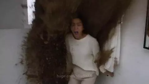 Woman in white sweater and beige pants screaming as a huge wave of brown sewage erupts from a toilet behind her in a white bathroom.