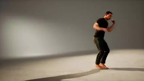 Male martial artist in fighting stance, bare feet kicking up dust, with dramatic shadows.