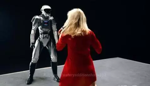 Blonde spy woman in red and white performing a sidekick against a Martian robot on a futuristic stage.