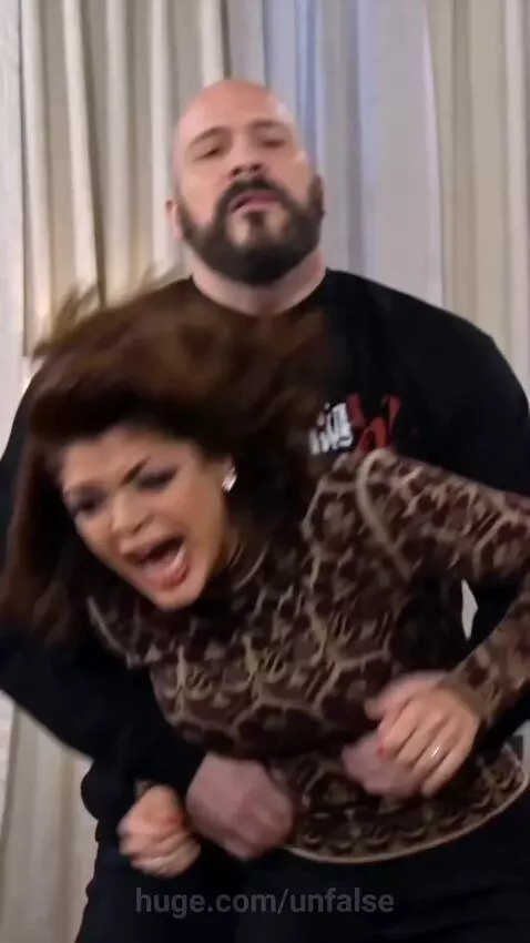 A woman angrily confronts another woman while a man tries to intervene, with a wheelchair visible.