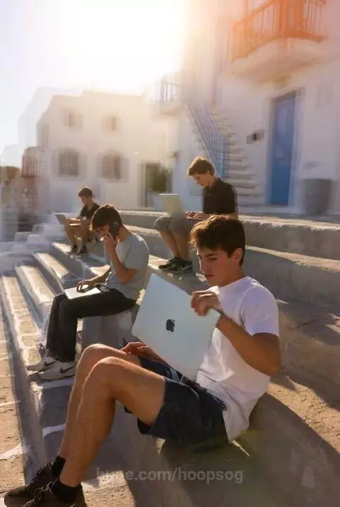 Man doing tricep dips on stone steps in a sunny, white-washed village in Mykonos, Greece.