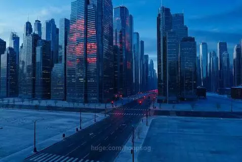 A modern, empty city at dusk or dawn with towering blue-lit skyscrapers and deserted streets.
