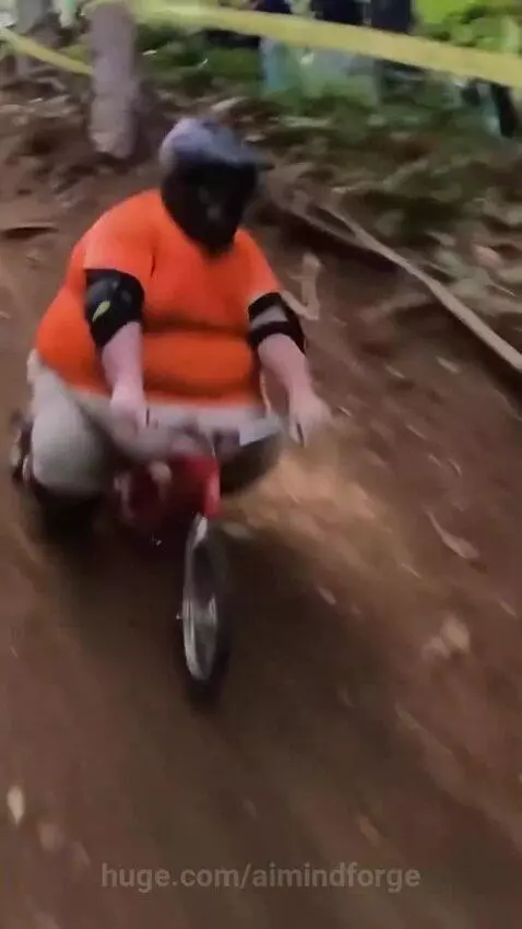Large man in helmet and gear riding a small tricycle-like bike downhill, performing stunts.