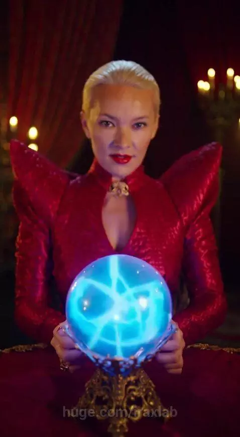 Woman in red dress with red lipstick asks a glowing blue crystal ball 'How hot am I?'