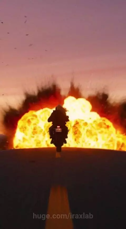 Blonde woman on a motorcycle riding away from a massive explosion on a desert road at sunset.