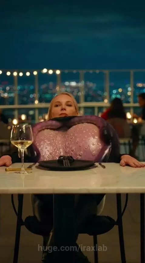 Woman transforming into a purple octopus creature holding a microphone at a rooftop restaurant.