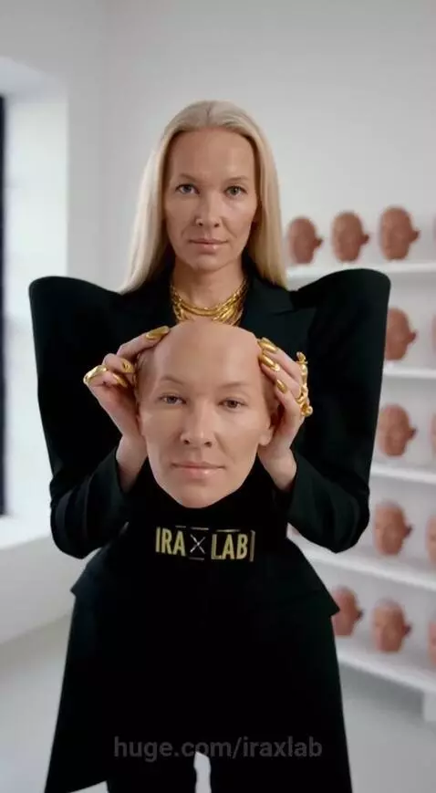 Woman holding a bald, lifelike head with 'IRA LAB' on the neck, demonstrating its skin-like texture.