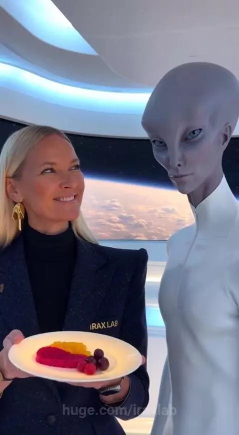 Woman in futuristic lab with alien, holding plate of 3D printed fruit, with Earth screen in background.