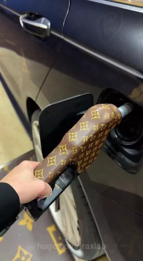 Woman in a black blazer at a gas station completely covered in Louis Vuitton monograms, holding a bag of chips.