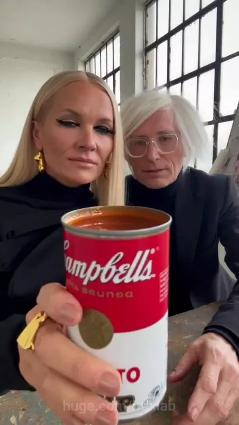 Man and woman in art studio opening and attempting to drink Campbell's soup from cans, with spills.