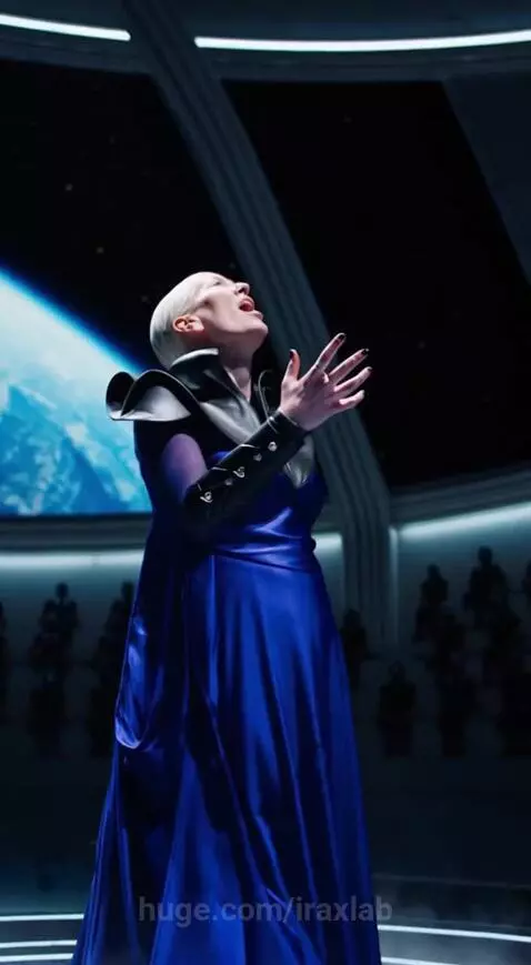 Diva Ira from The Fifth Element in a blue gown performing opera on a futuristic stage with Earth visible in the background.
