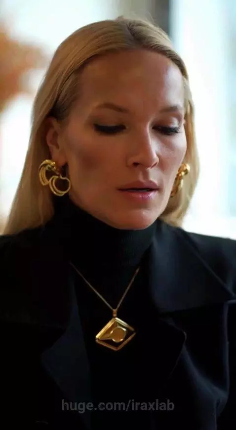 Blonde woman in black outfit and gold jewelry walking through urban settings and riding the subway.