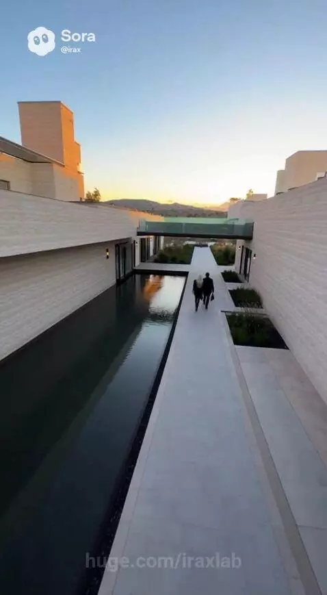 Woman in high-fashion outfit walking through a modern luxury house with minimalist design and water features.