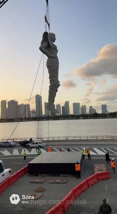 A large grey statue falling and shattering on a platform, with a woman in black watching in shock.