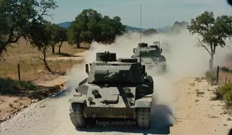 Military tanks driving down a dusty rural road, kicking up large plumes of dust.