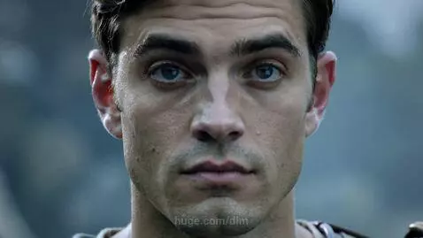 Close-up of a man with fair skin and blue-gray eyes, transitioning from a neutral expression to a warm, genuine smile.