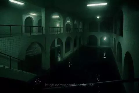 Dark, abandoned indoor pool room with arched walkways and dim lighting, reflecting in the still water.