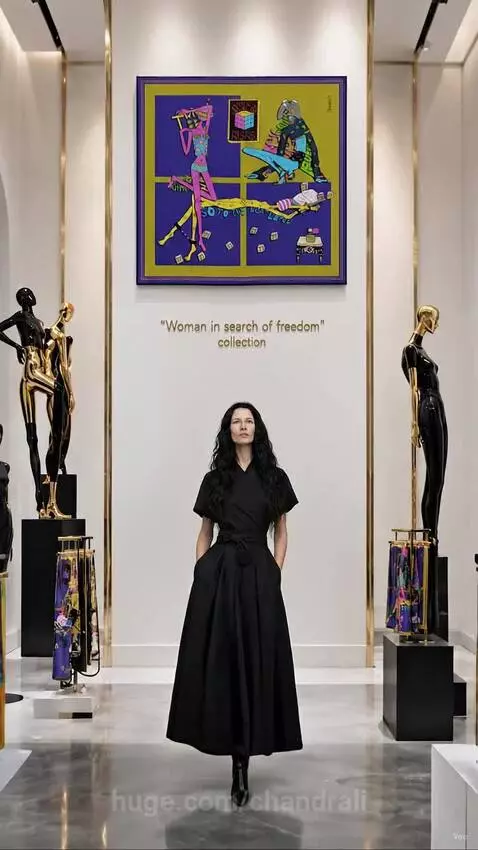 Woman in a black dress with a vibrant scarf transforming into a headscarf, standing near mannequins.