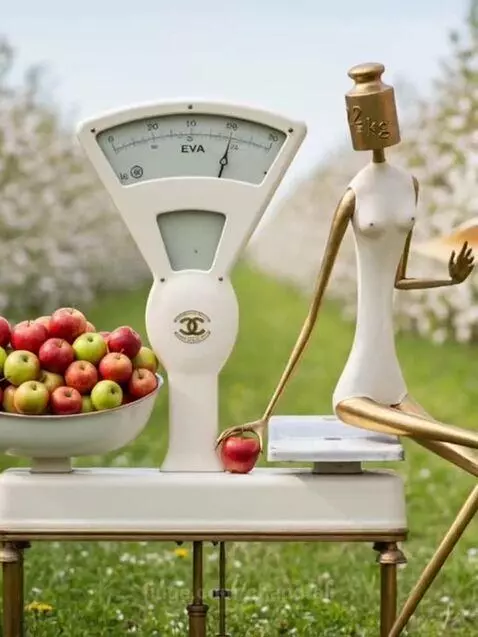 Vintage scale with apples, a figure with a weight for a head, transforming into a bride in an apple orchard.