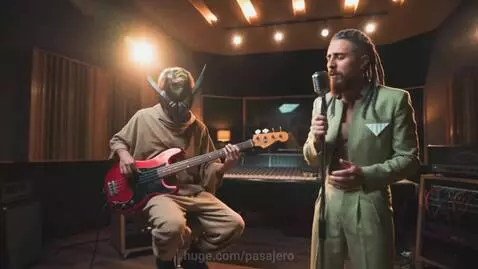 Band performing in studio with neon car racing scenes, lead singer in green suit, bassist with horned mask.
