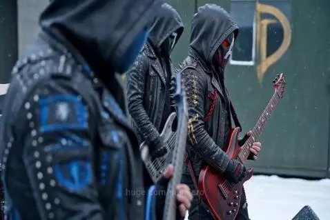 Lead singer of a masked rock band performing in a snowy, industrial landscape.