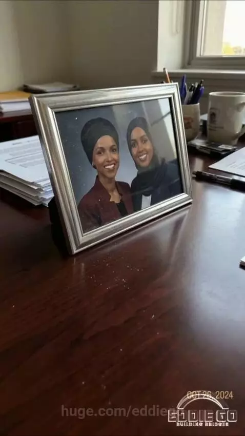 Man in suit pointing at animated graphics showing money flow to a clinic linked to Ilhan Omar and her sister.