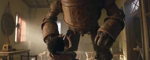 A young child with curly hair hugs a large, rusty humanoid robot in a dusty, sunlit room.