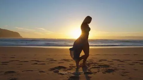 Rising sun on the face of a damsel at the beach by mia