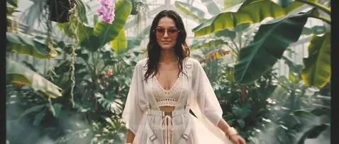 Woman in bikini and cover-up skydiving and landing in a martini glass.