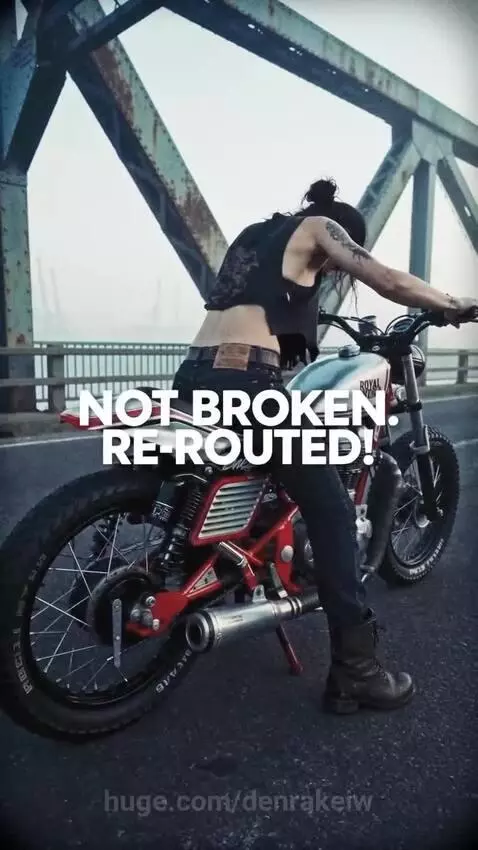 Woman performing a wheelie on a custom motorcycle on a foggy truss bridge, then jumping off a ramp.